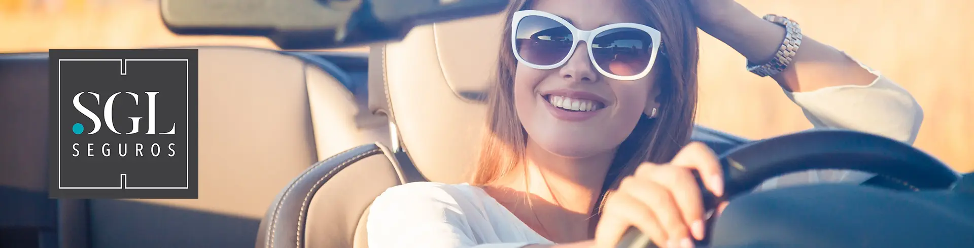 mulher feliz a conduzir automóvel com seguro barato da SGL Seguros